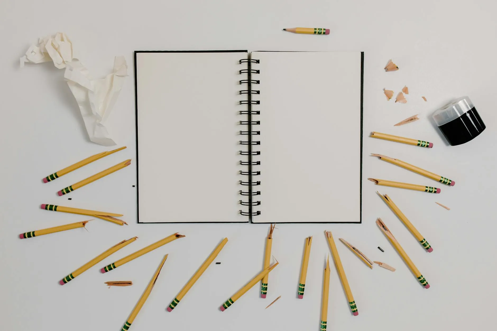 Close-up of a student's hands arranging study notes around a hand-drawn concept tree diagram on a wooden desk.