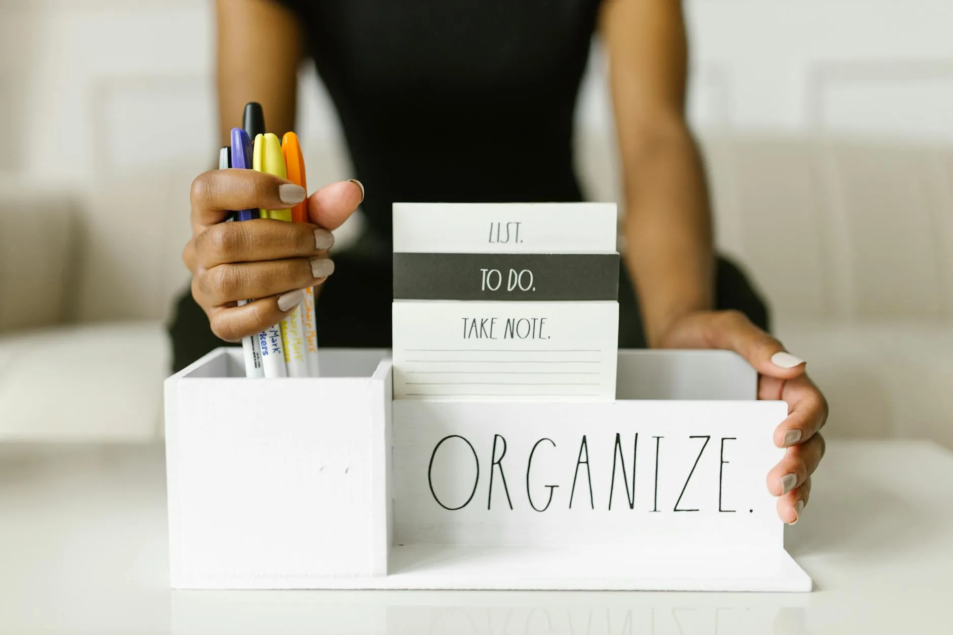 Student's hands creating digital flashcards on a tablet at a cluttered dorm desk