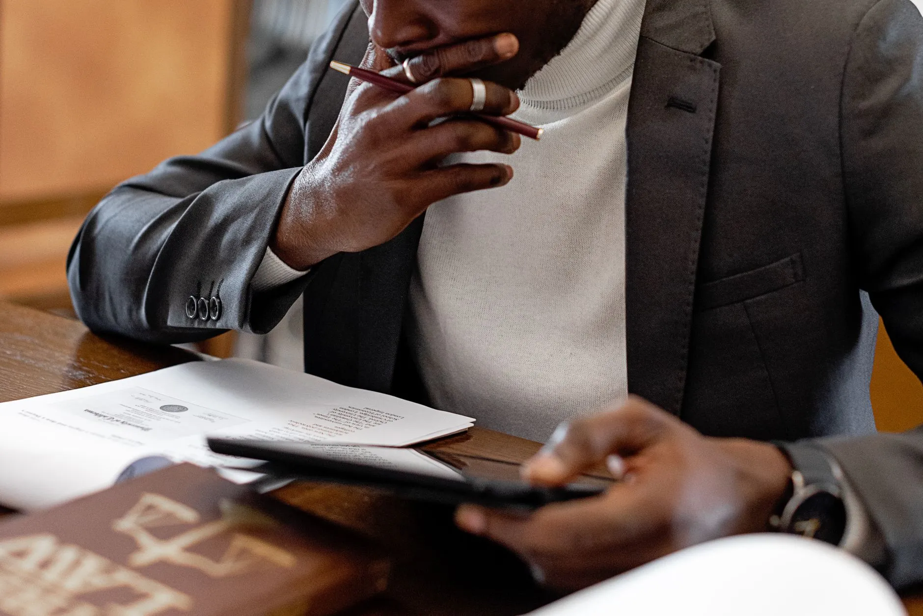 Close up of student hands using a tablet to generate flashcards on a messy wooden dorm desk