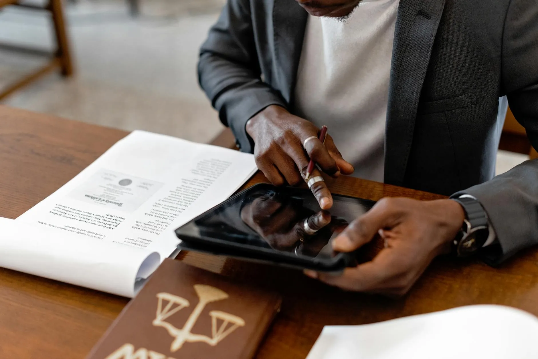 Close-up of a student's hands creating digital flashcards on a tablet at a cluttered desk