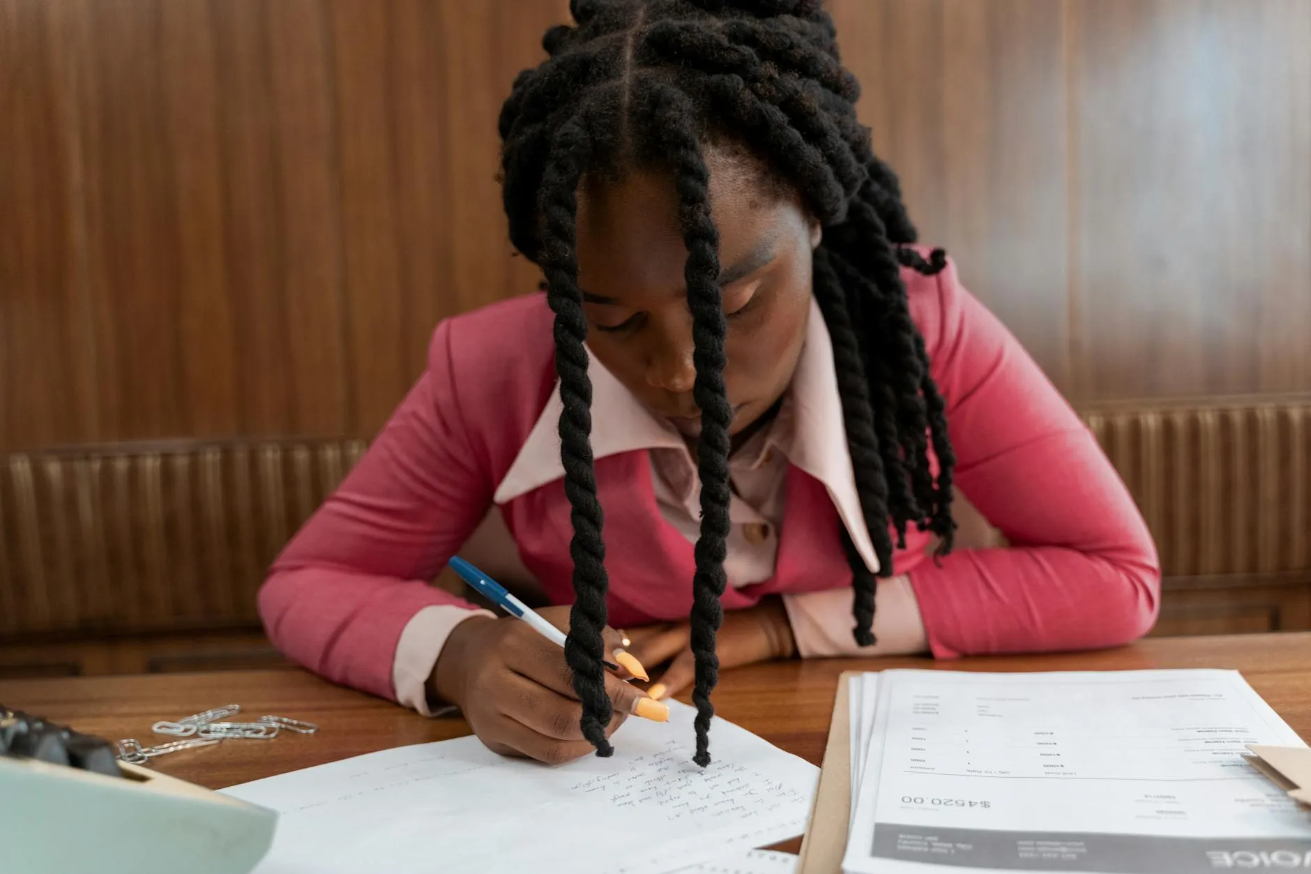Close-up of a student's hands using a tablet to create digital flashcards on a slightly messy dorm room desk