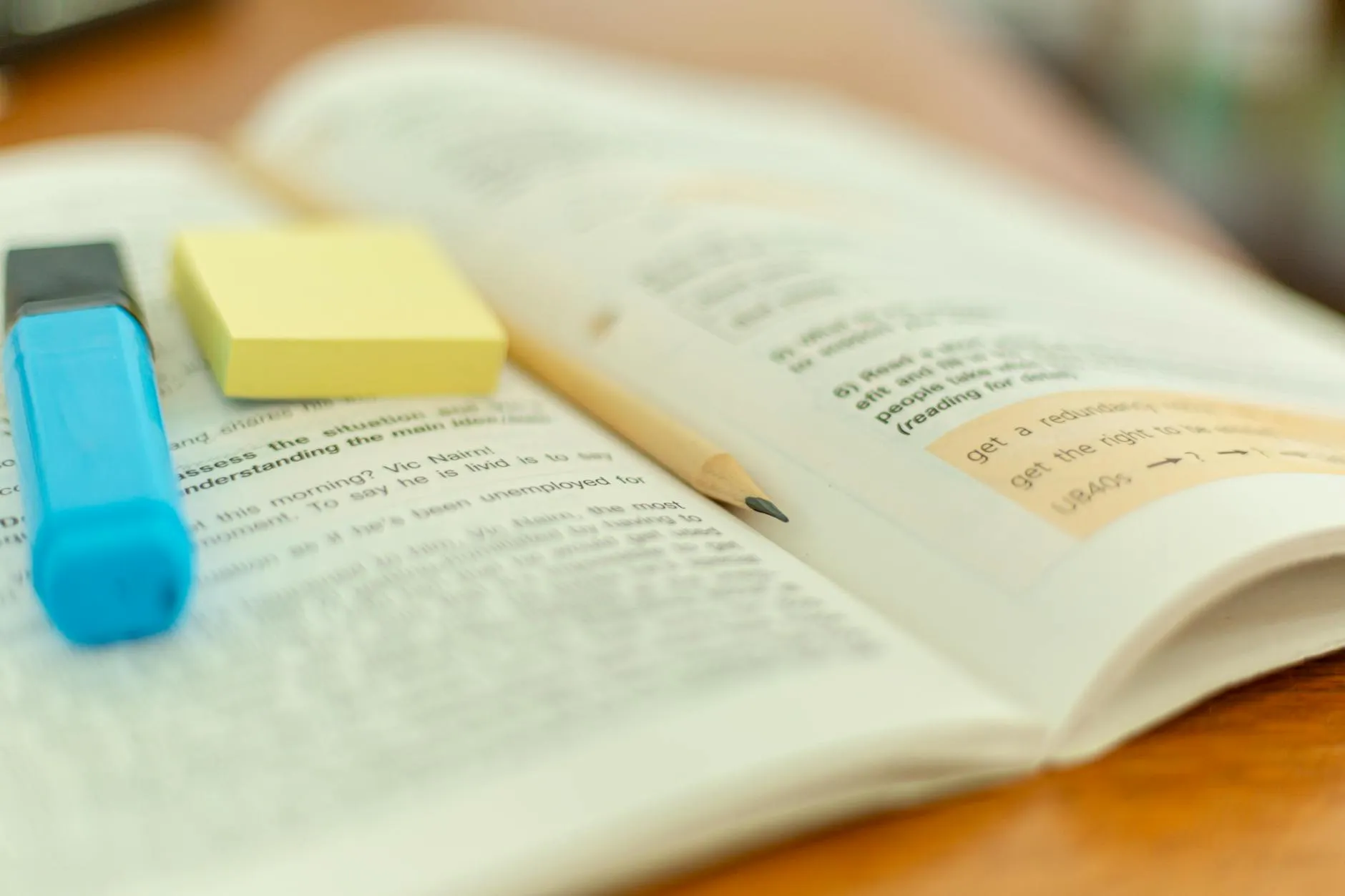 Close-up of hands highlighting notes in a Series 7 textbook on a messy desk.