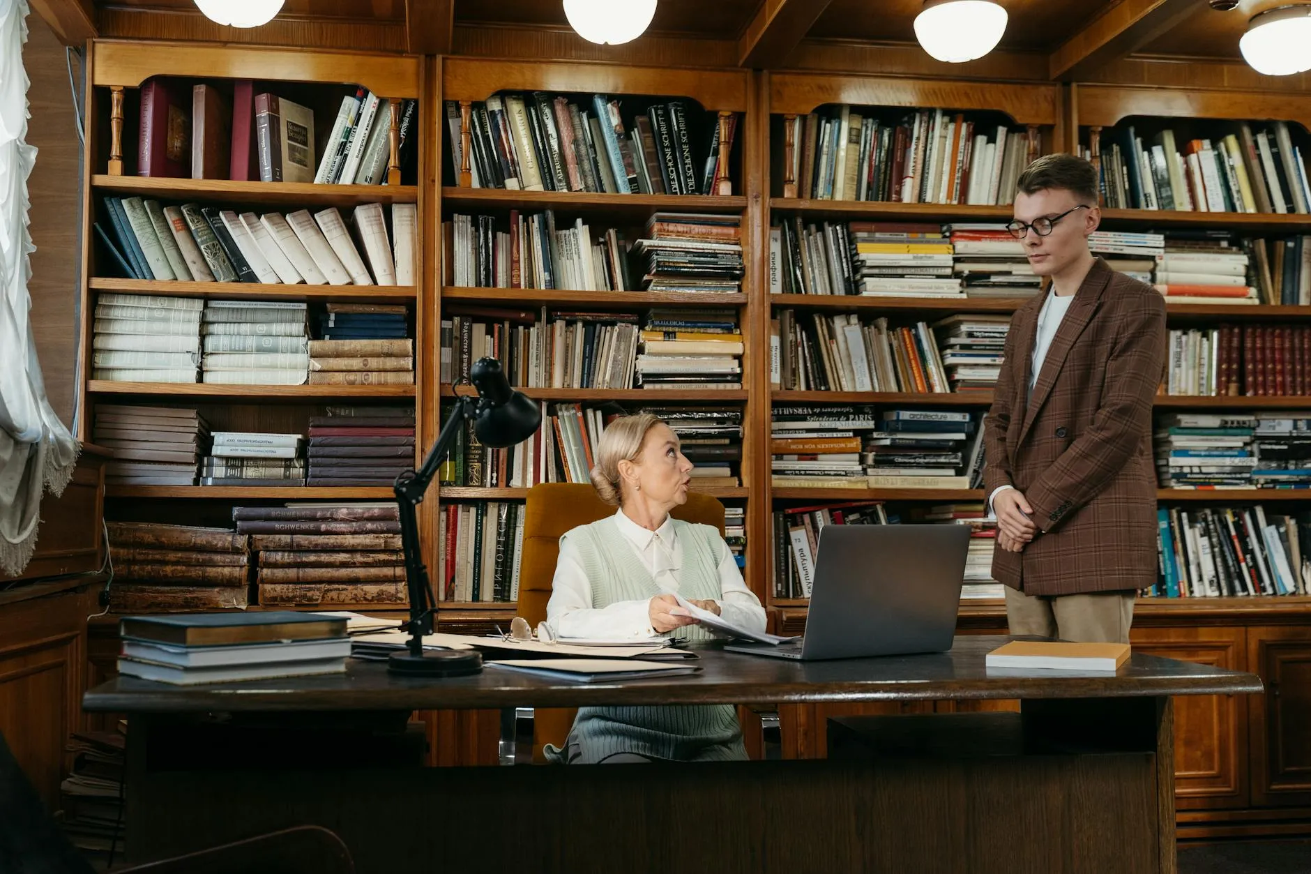 A student and a professor having a productive conversation in a sunlit university office