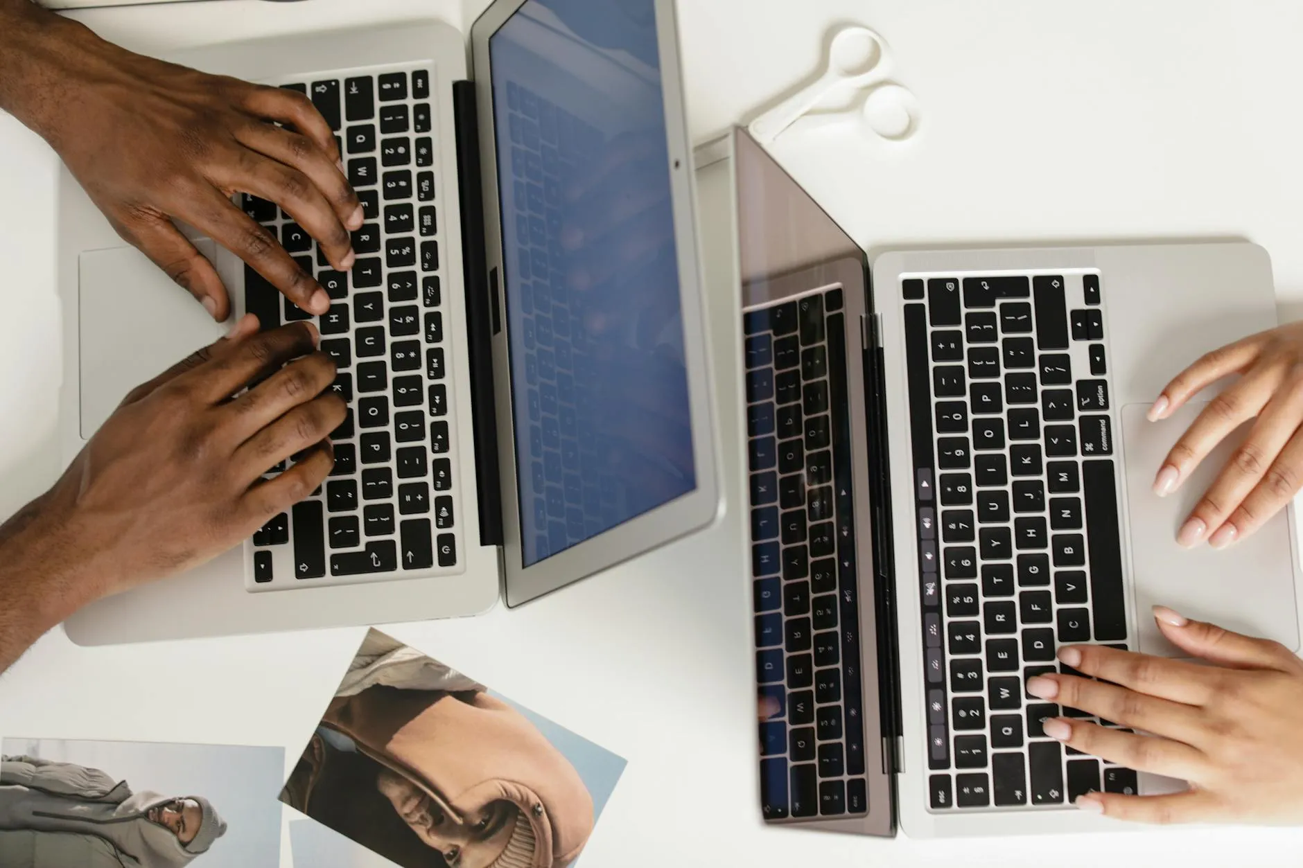 Close up of a student's hands using a laptop on a messy dorm room desk with coffee and notebooks