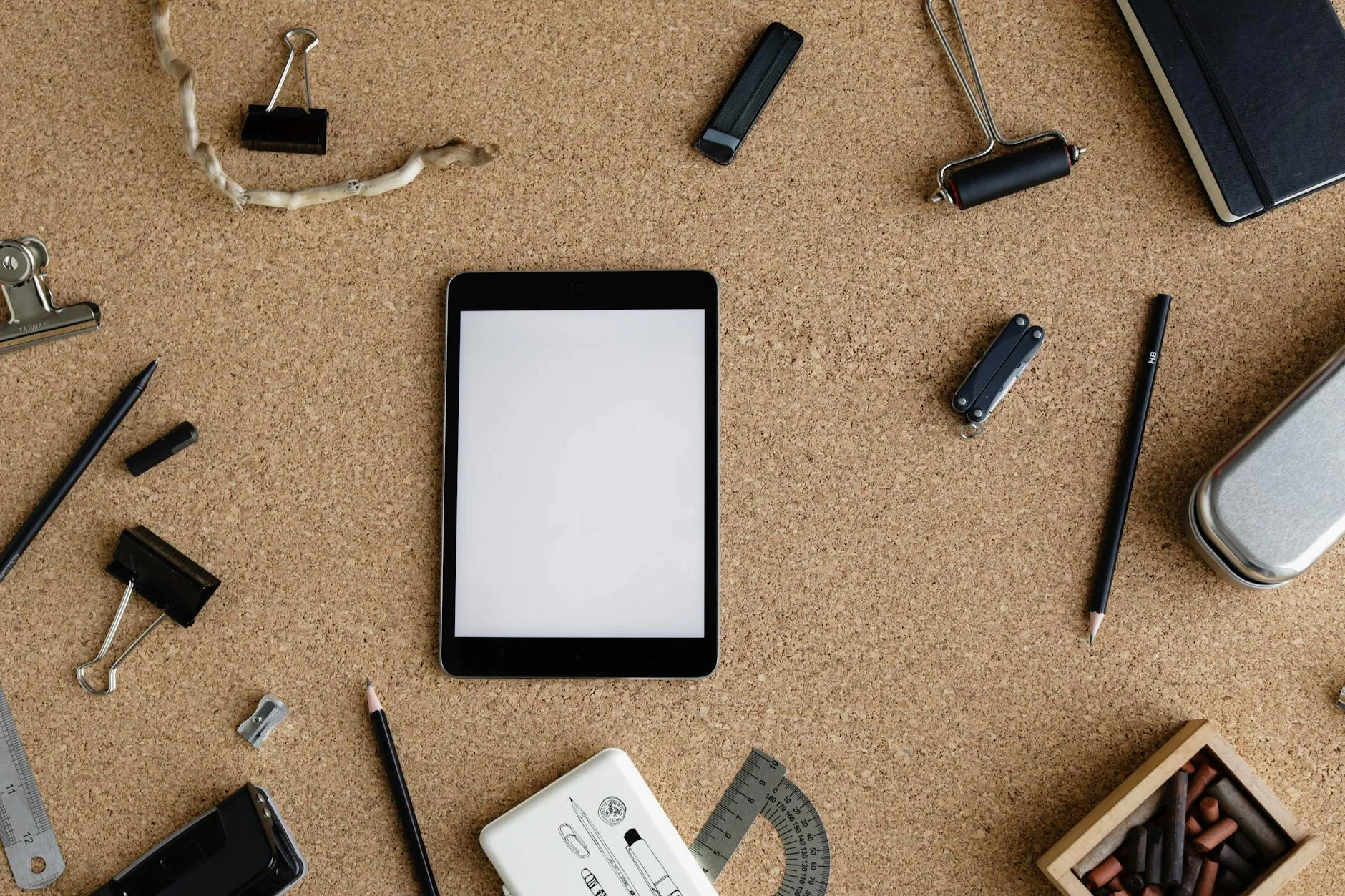 Close-up of student's hands creating digital flashcards on a tablet at a messy desk